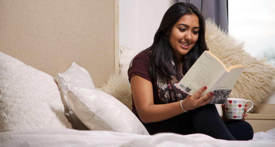 A student reading on her bed