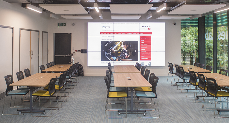 An image of the videowall in Seminar Room 1, showing the arrangement of the tables and chairs