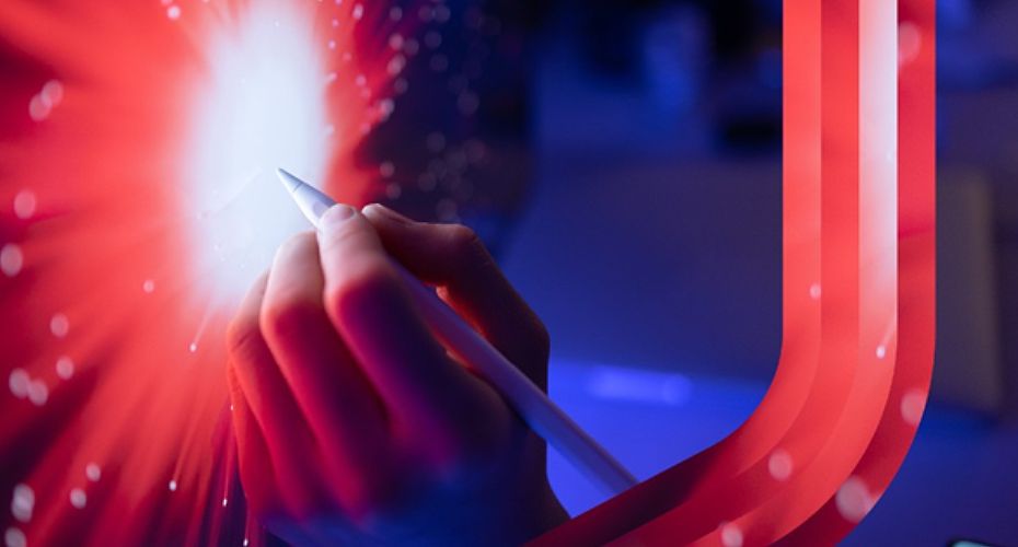 A person holds a pen in front of a glowing red light