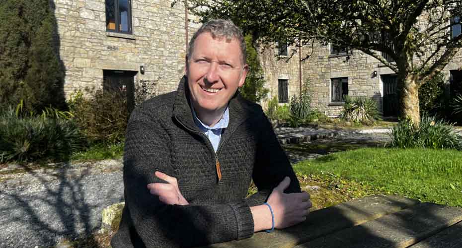 Ben Hud sat outside smiling into camera