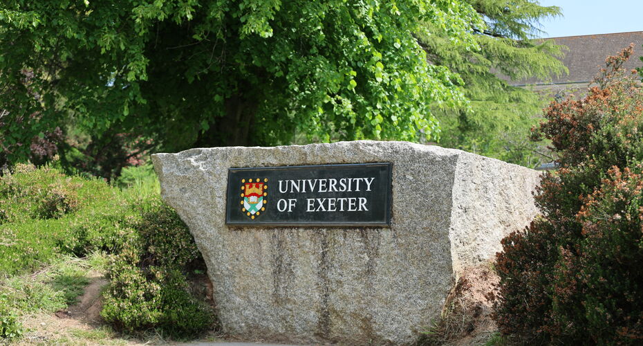 A big rock with a plaque reading University of Exeter