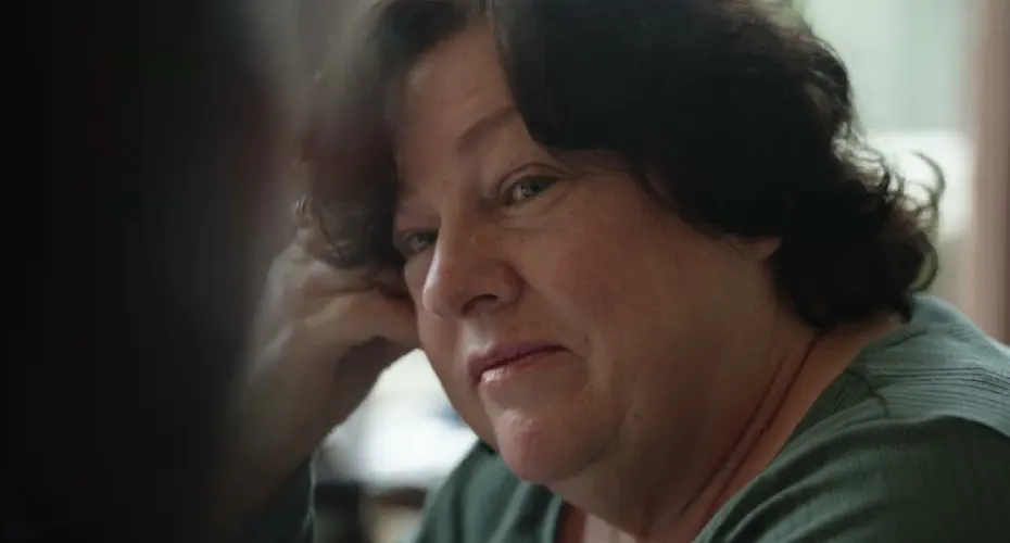A woman with a large head gazes at the camera, featured in the Digital Animals documentary.