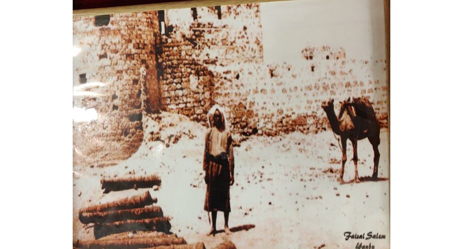 More than a century old picture of a man and a camel carrying water standing at the gate of Yanbu al-Bahr (photo Faisal Salam year [?])