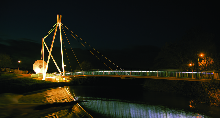 Illuminated bridge at night over river Exe