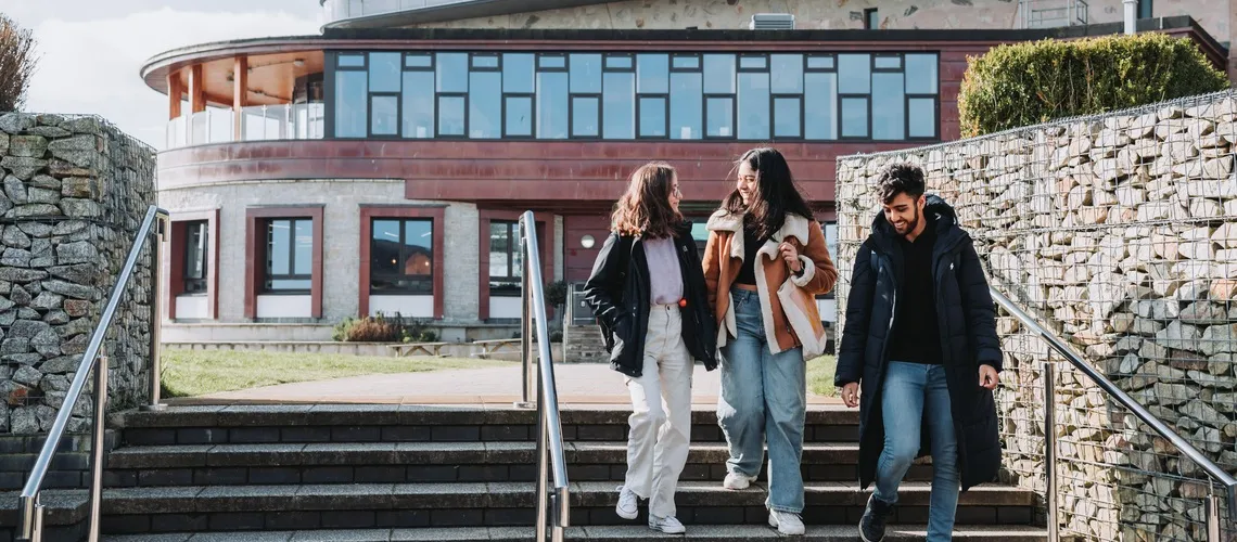 A group of students walking across Penryn Campus together.