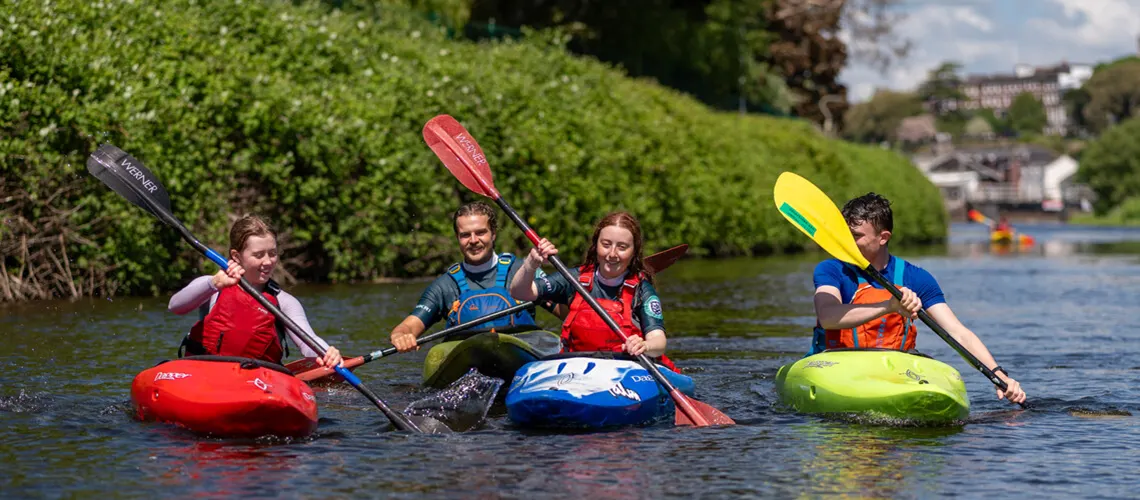 A group of undergraduate students kayaking together in the Exeter Canal.