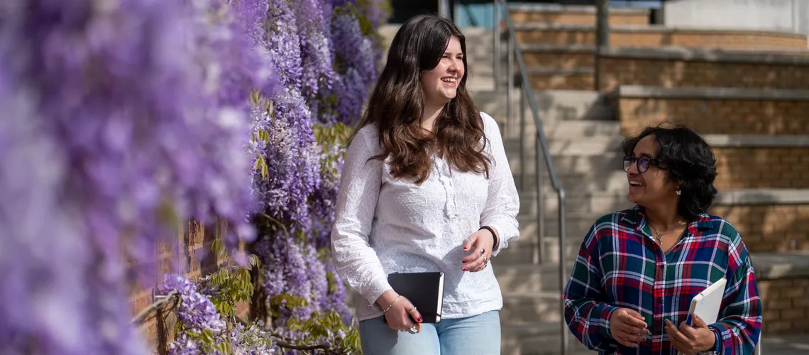 Two students walking together around Streatham Campus in Exeter.