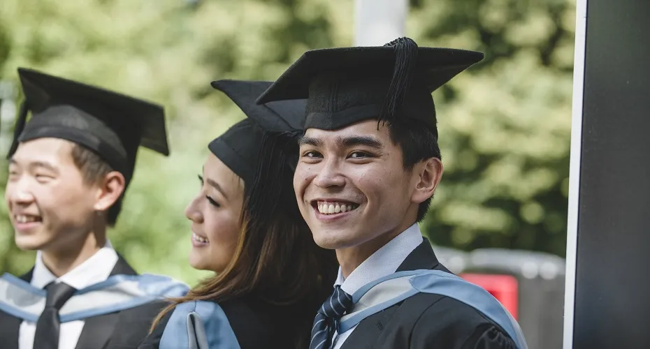 A student pictured smiling at the Streatham Campus Summer Graduation.