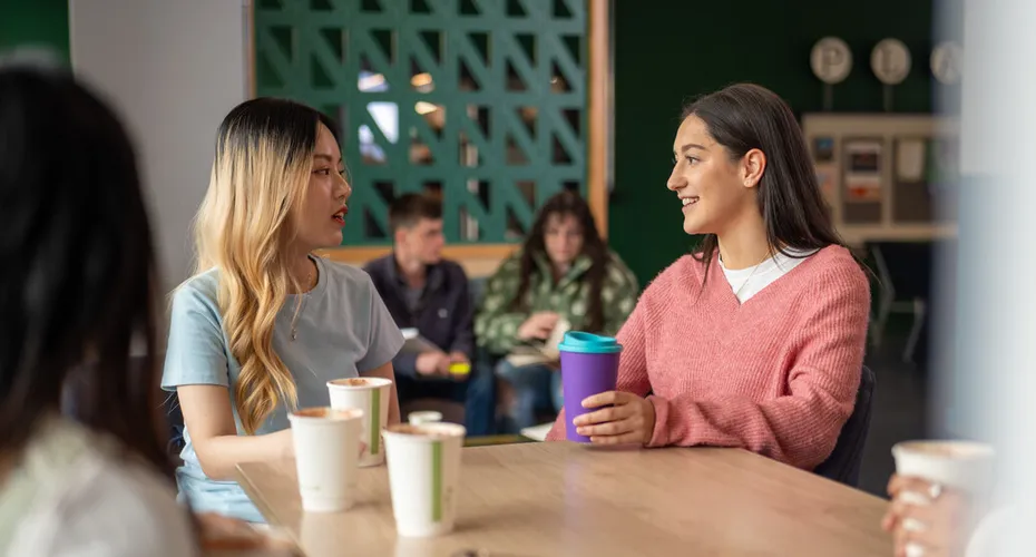 Two international students in Exeter city centre enjoying coffee together.