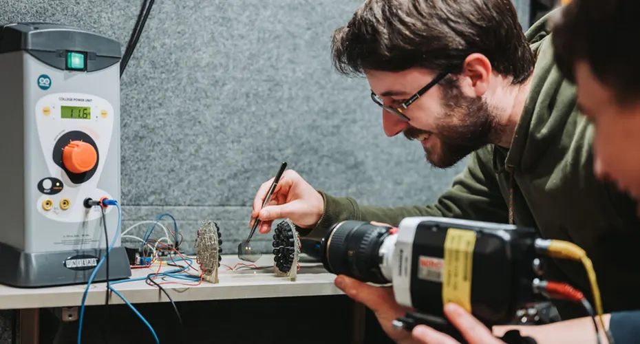 Two Physics students conducting a lab experiment.
