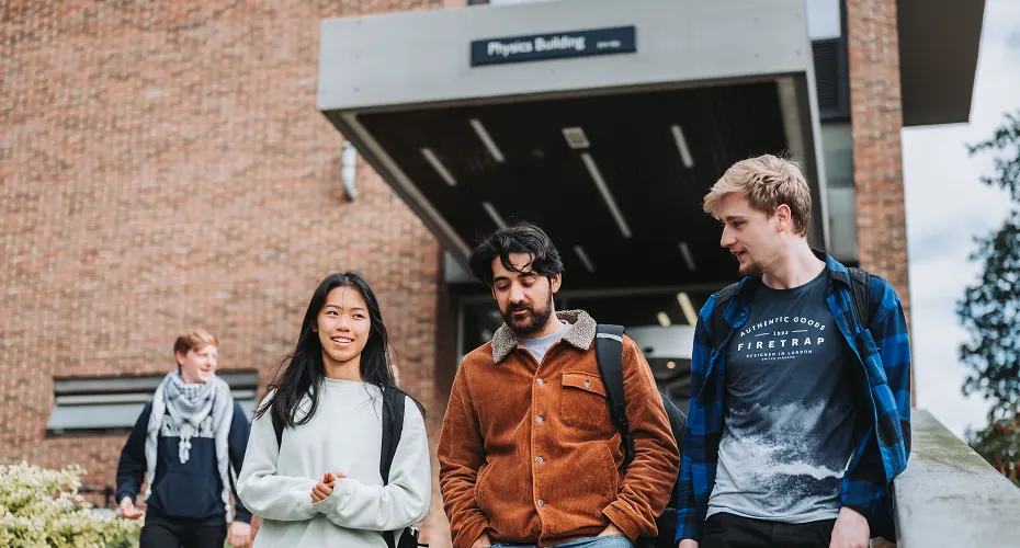 A group of Physics students stood talking outside of the Physics Building on Streatham Campus.