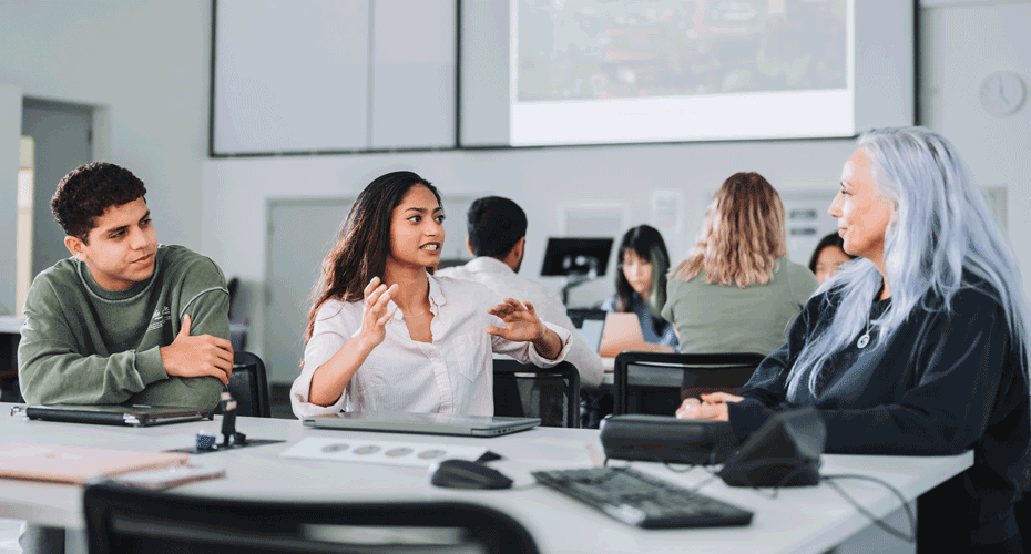 Students debating around a table in a seminar room