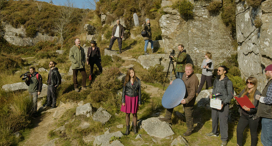A group of actors filming on a moor.