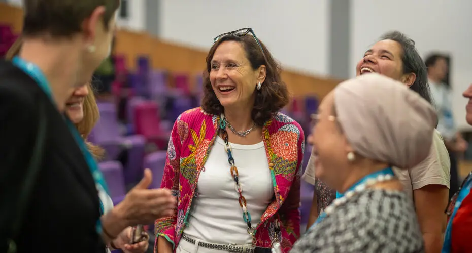Group of people chatting and laughing together at a conference.