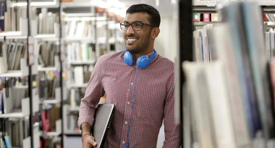 A Degree Apprenticeship student stood in the library