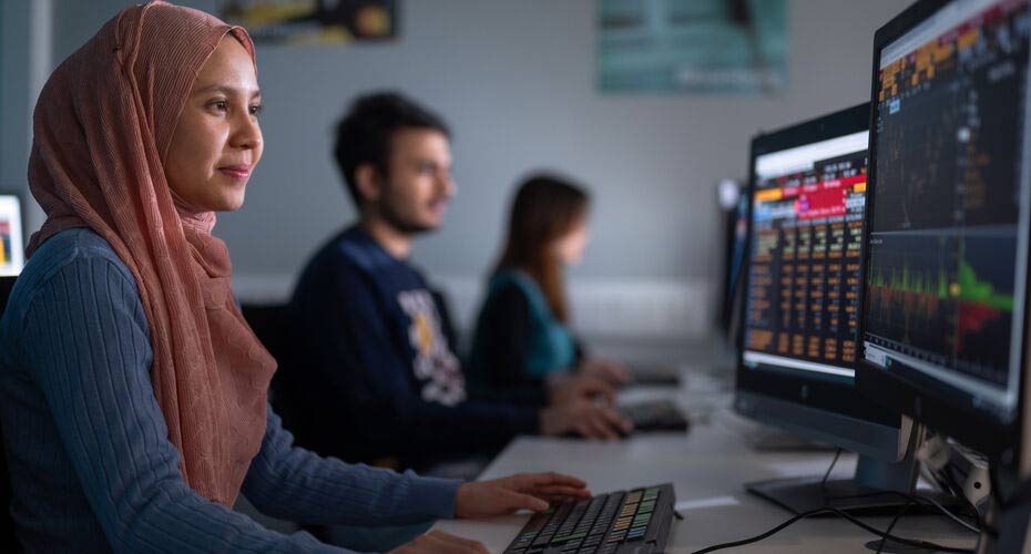 A student sat at a PC learning to code