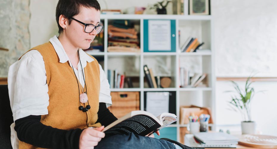 A student reading in the library on the Penryn Campus