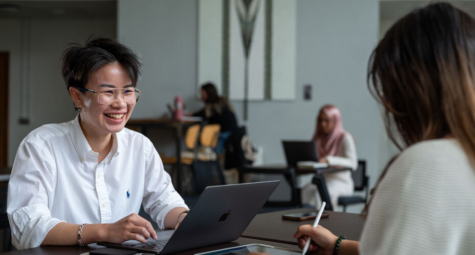 Students sitting at a table and chatting.