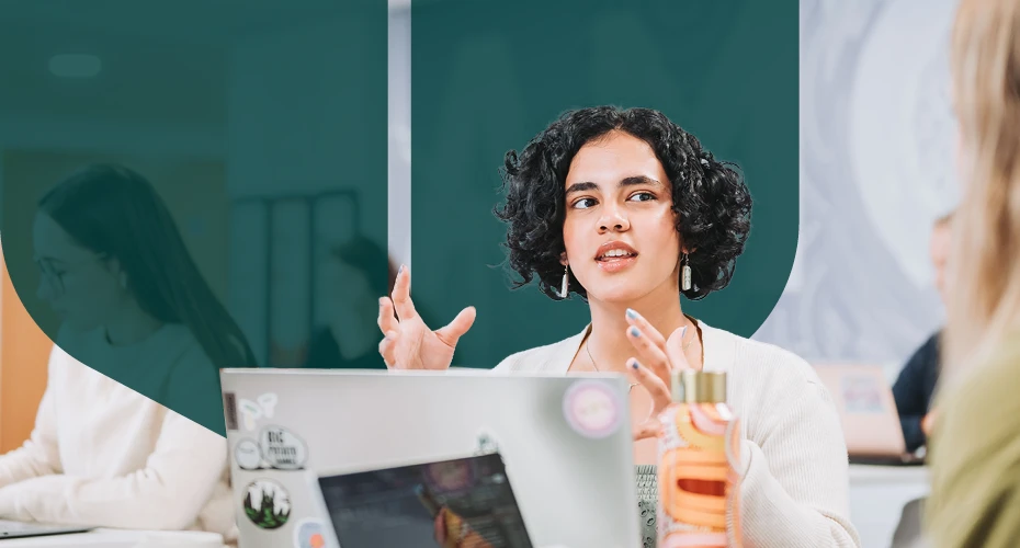 A lady sat at a desk talking to other people