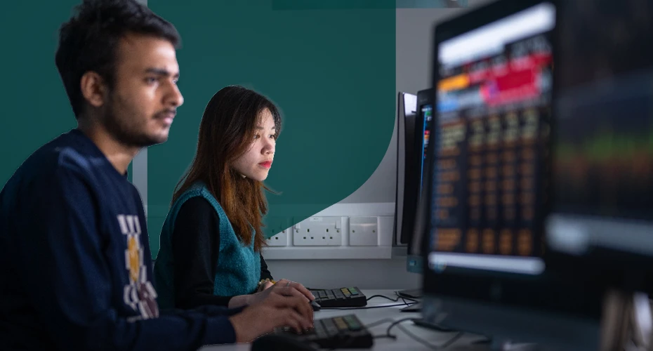 Students sat at a desk looking at computers