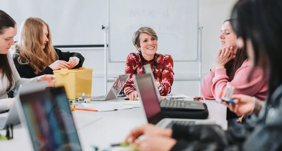 Students sat around a table with their lecturer