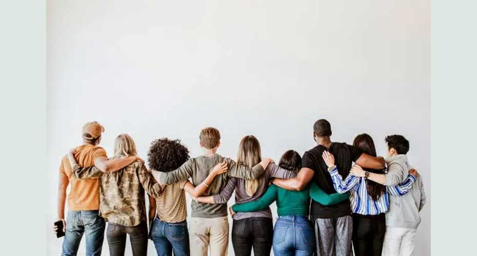 Group of people looking away from camera with hands around shoulders