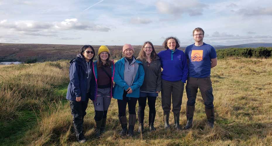 six scientists standing by a river bank