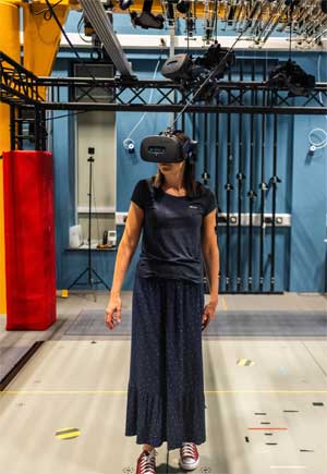 A lady walking around lab in VR headset