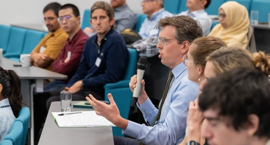 A speaker interacts with a group in a lecture hall at the LEEP@10 event, facilitating audience questions and discussion.
