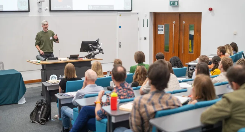 Ben Groom delivers a lecture to a large audience at the LEEP@10 event, engaging attendees with his presentation