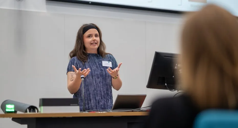 A speaker, Cassie Bird, addresses a crowd at the LEEP@10 event, sharing insights and knowledge with participants.