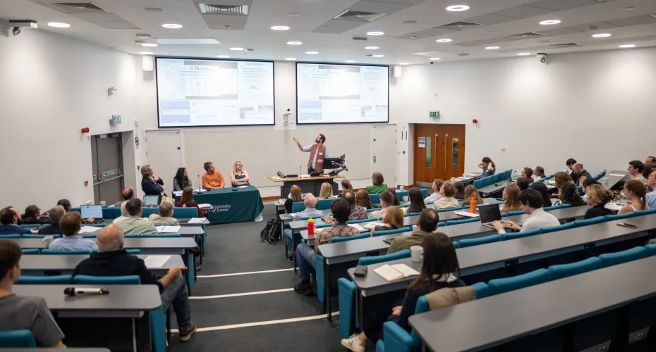 Daniele Rinaldo delivers a lecture to an audience at the LEEP@10 event in a spacious lecture hall.