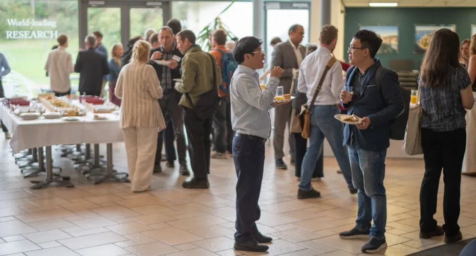Attendees networking during lunchtime at the LEEP@10 event, gathered around tables with food and drinks.