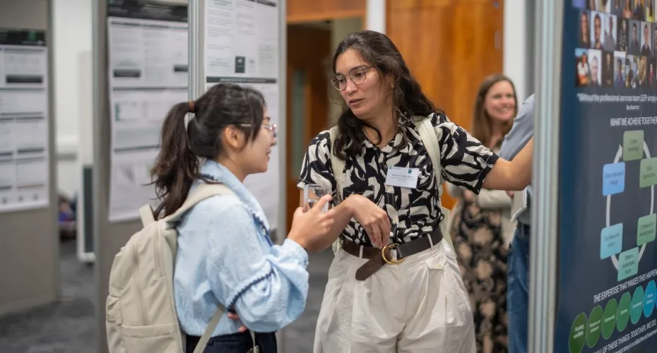 Tatiana Garcia discusses her research poster with a delegate at the LEEP@10 event, showcasing collaboration and engagement.
