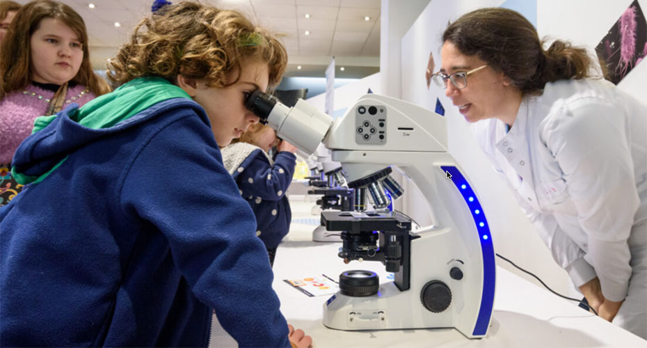 School child looking down a microscope