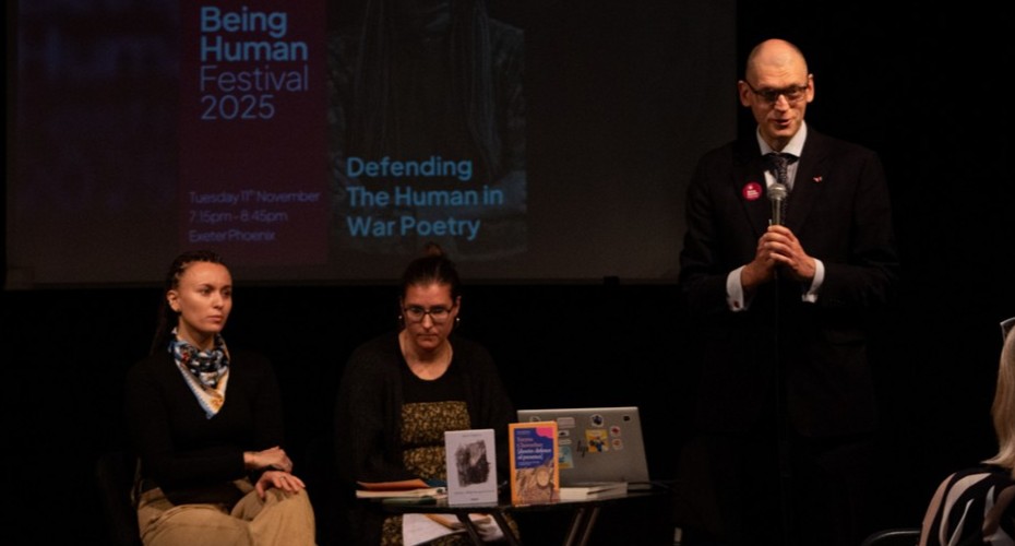 A group of people presenting in a dark hall