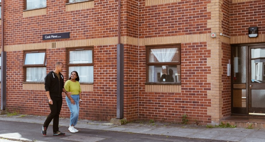 Two smiling students standing outside Cook Mews accommodation