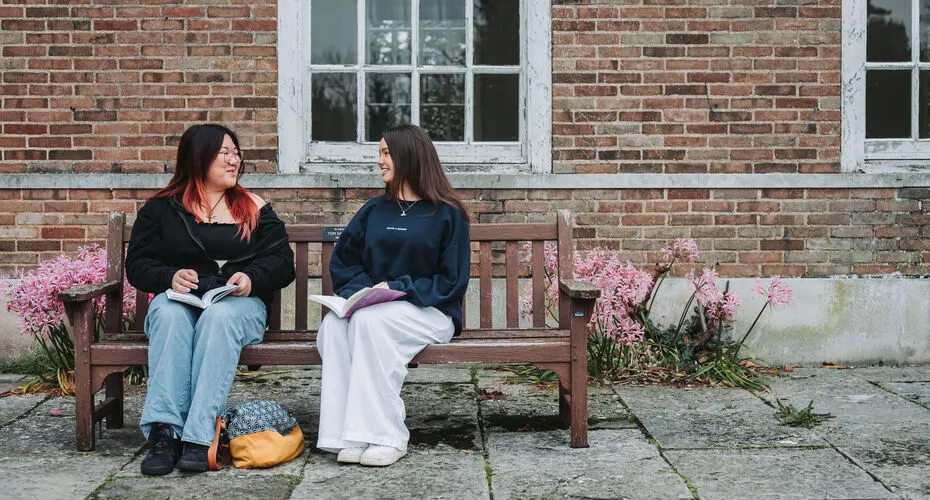 A pair of students chatting outside of Lopes Hall on Streatham Campus.