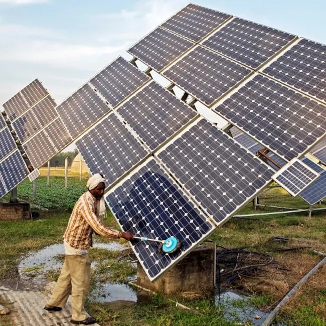 A man cleaning soloar panels ina field. Credit: Prashanth Vishwanathan, IWMI