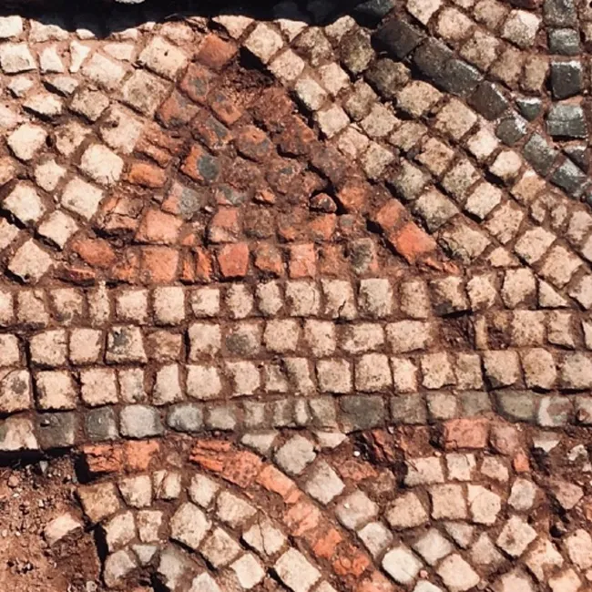 A roman mosaic with red and white tiles.