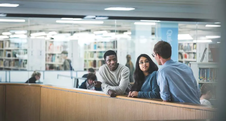 Students chatting outside the library at penryn campus.