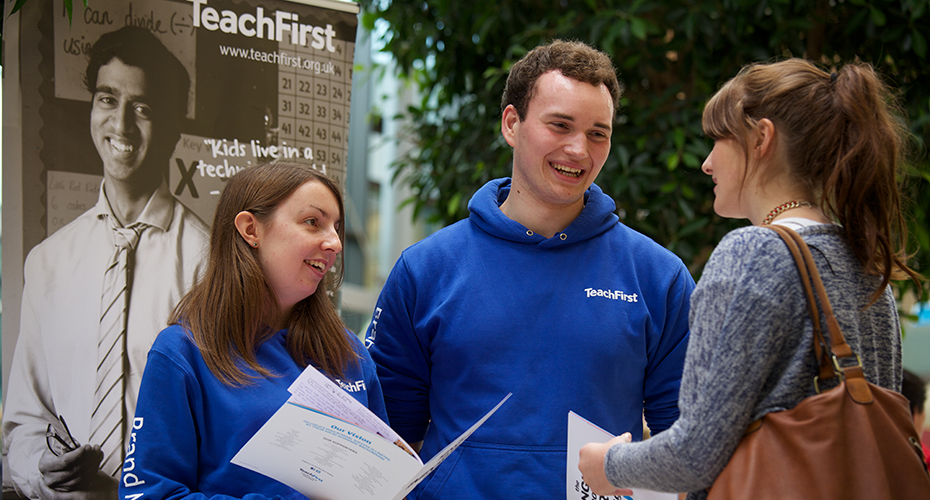 An employer talking to a student passing by at a drop-in