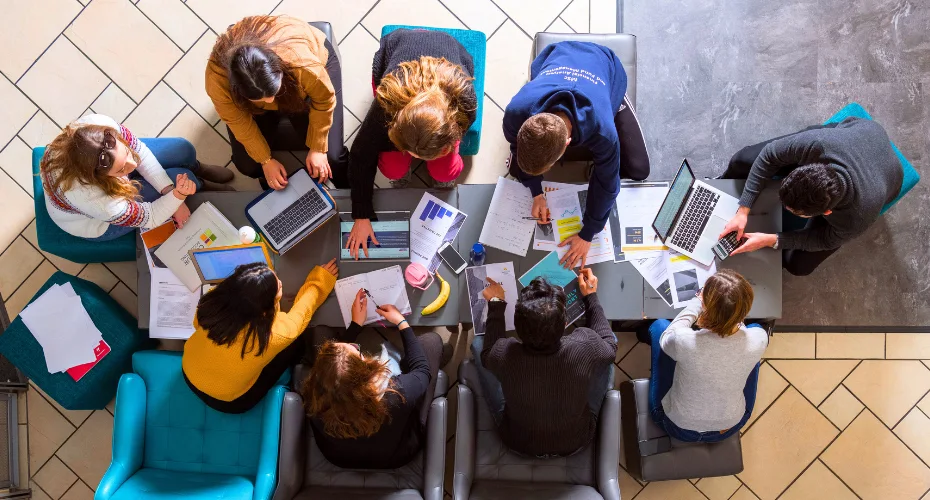 Group of students working on a projct around a table at the Business School
