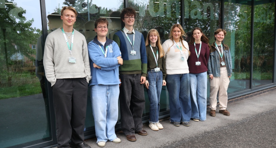 Group of students standing by a window