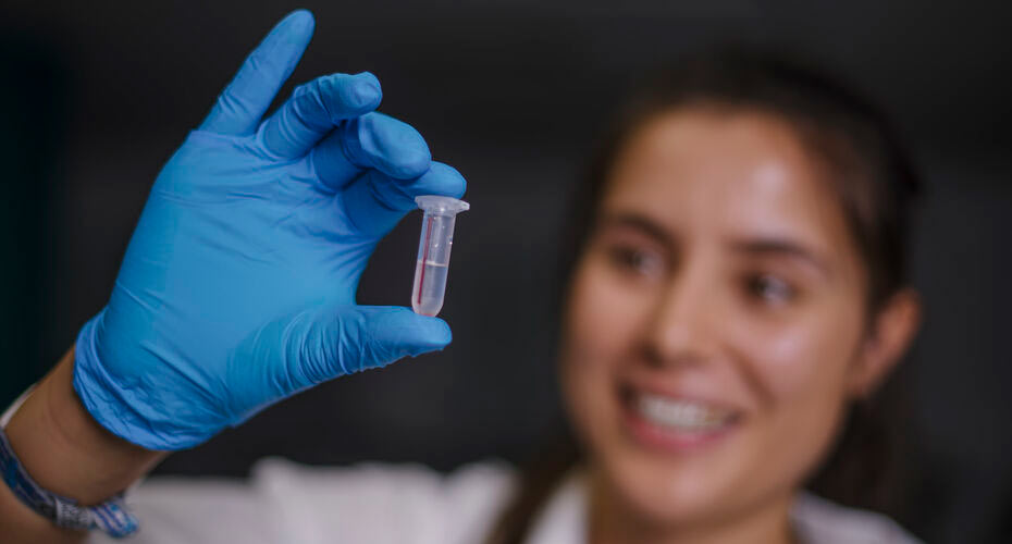 A postgrad sutdent holding a test tube