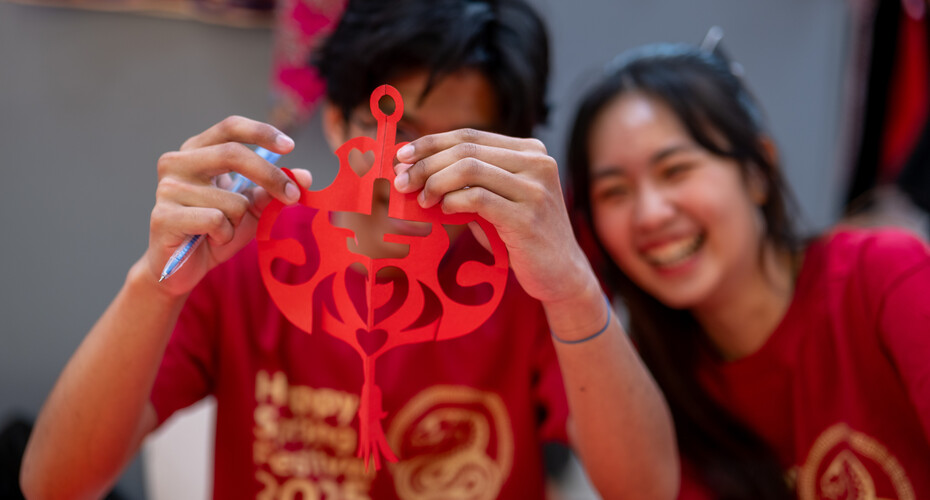 A student holds up a Spring Festival decoration
