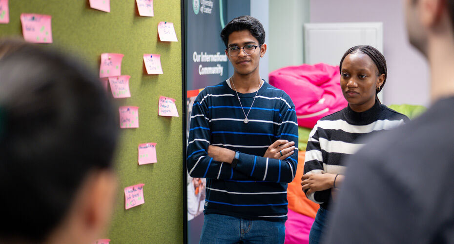 People in a workshop next to a board with post-it notes
