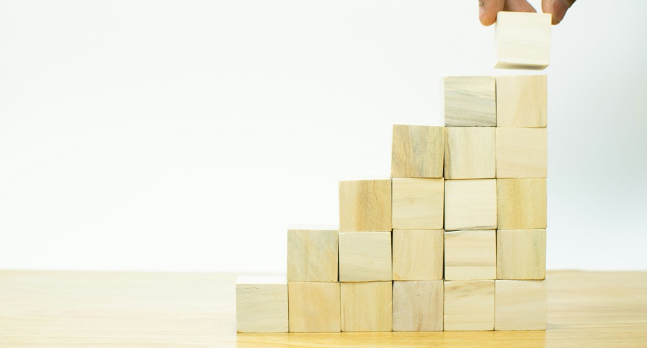 A hand is placing a block into a pyramid