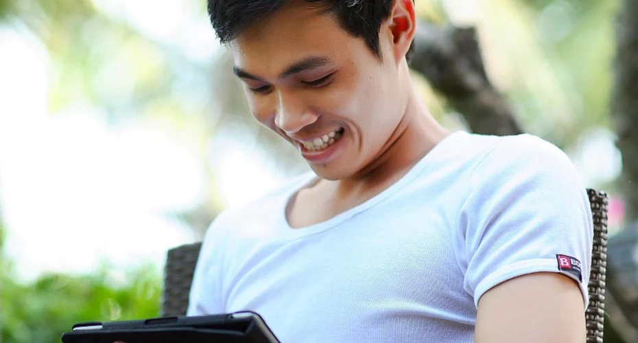 A man seated on a chair, smiling warmly, exuding a sense of happiness and contentment.