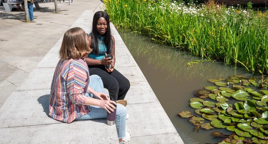 Staff sitting by pond
